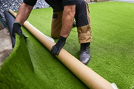 The Grounds Guys service professional installing artificial turf.