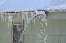 Icicles being removed from a home's gutter.