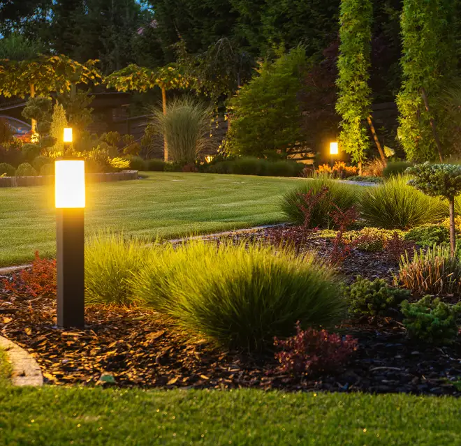 Lawn lights illuminating a commercial lawn at night.