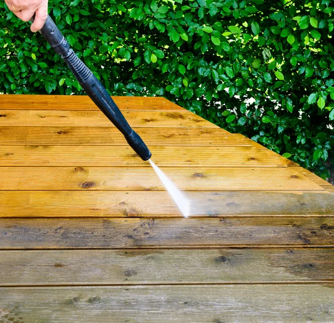 Pressure washing a wood deck.