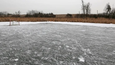 An ice hockey net sitting on an outdoor rink